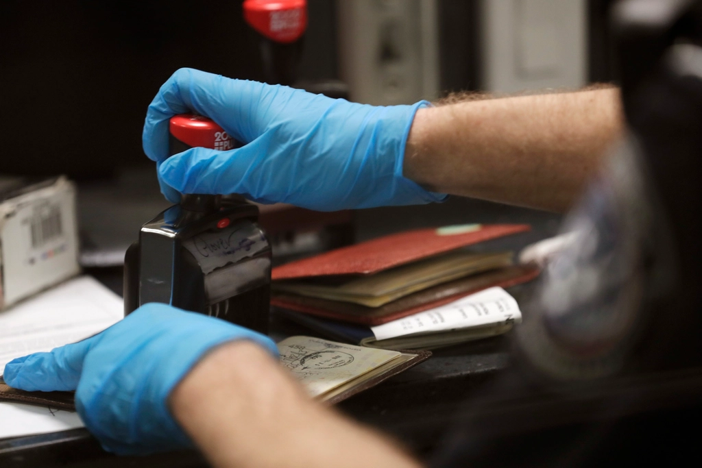CBP-Stamp-Passport The gloved hands of a CBP officer stamping a passport