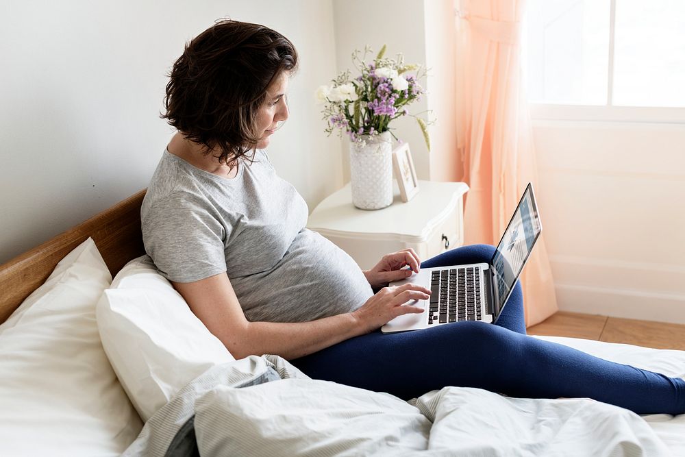 Pregnant woman using computer laptop Photo rawpixel