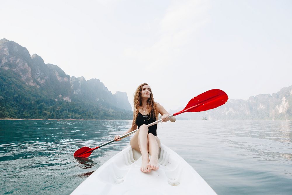 Woman paddling a canoe through a national | Premium Photo - rawpixel