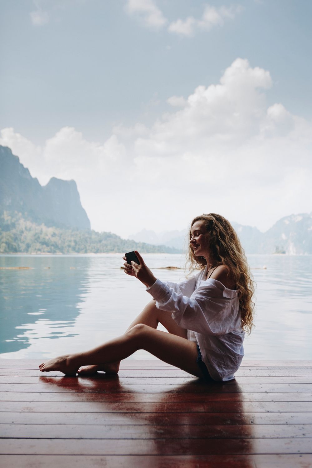 Woman using her phone by a lake | Premium Photo - rawpixel