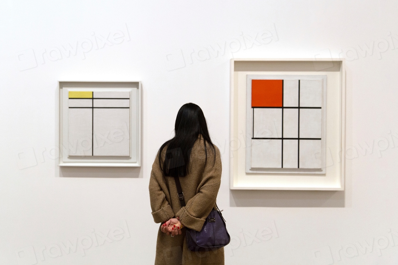 Photo of a woman standing and looking at two Mondrian paintings