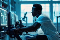 A black Athlete riding an exercise bike in a lab during biometric testing electronics hardware monitor.
