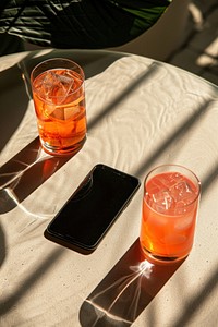 Smartphone on glass-table cocktail electronics beverage.