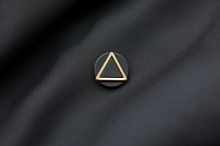 Minimalist lapel pin triangle symbol logo.