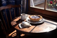 Cappuccino and a slice of freshly baked blueberry pie window table cup.