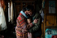 Bhutanese man hugging pregnant wife blanket people person.
