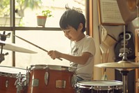 Teacher teaching boy playing drums at music classroom recreation percussion performer.