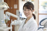 A asian woman dentist smile aganist dental furniture female person.