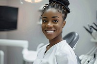 A black woman dentist smile aganist dental electronics hardware monitor.