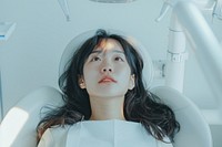 Asian woman mouth open sitting on dentist chair architecture building hospital.