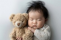 Asianbaby newborn sleep and cuddle teddy bear photography portrait sleeping.