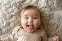 Baby newborn sticking tongue out on bed photo photography portrait.
