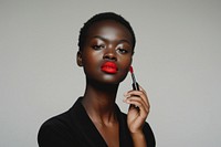 Black holding red lipstick with confident pose photo photography cosmetics.