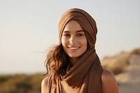 A girl wearing a brown hair scarf happy photo face.