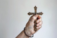 Hand holding cross or crucifix pray worship symbol prayer.