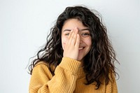 Woman covering one eye with hand smile face surprised.