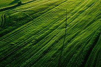 Aerial view of a green field with a power line in the middle of it countryside outdoors nature.