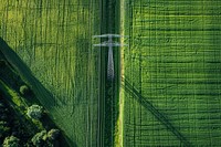 Aerial view of a green field with a power line in the middle of it countryside outdoors nature.