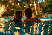 Young couple traveler relaxing and enjoying a tropical resort pool romantic bathing jacuzzi.