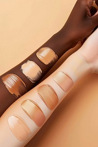 Liquid face foundation swatch in shades of skin tone colors arm person device.