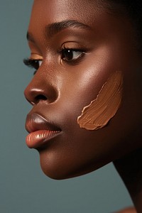 Liquid face foundation swatch on african american woman cheek person female human.