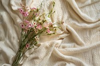 A bouquet of wild flowers on a beige cotton blanket blossom pattern plant.