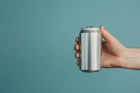 Person holding soda can tin.