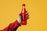 Person holding red bottle beverage ketchup drink.