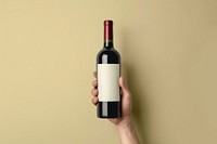 Person holding wine bottle cosmetics beverage alcohol.