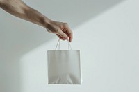 Hand hold white mini gift bag accessories accessory handbag.