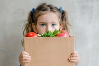 Box with food ingredients for donation child face female.