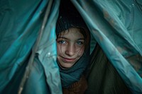 Ukraine refugee stands inside an old tent photography clothing apparel.