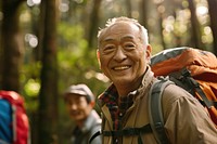 Smiling asian senior man hiking with friends backpacking recreation adventure.