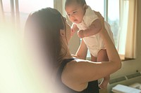 Mother holding her baby up with love