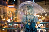 Blond woman taking cover under her umbrella