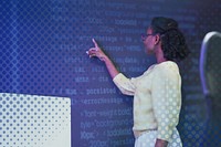 Woman analysing binary code on virtual screen
