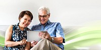 Senior couple using a digital device in a living room