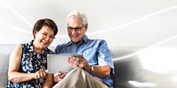 Senior couple using a digital device in a living room