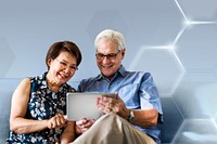 Senior couple using a digital device in a living room