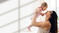Young mom holding her baby in the air blank space