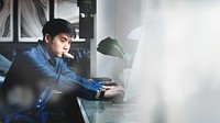 Blogger using a computer in his bedroom