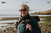 Senior tourist woman walking at the beach