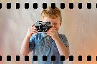 Cute boy playing with a camera