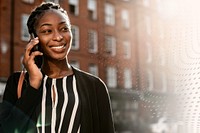 Black woman talking on the phone in a city