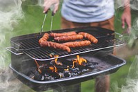 Man cooking sausages on grill