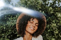 Beautiful woman listening to music in a botanical garden