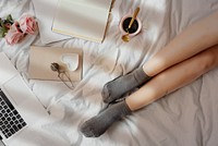 A pair of legs on a white bed sheet