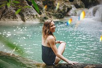 Beautiful woman at a waterfall summertime