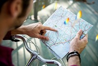 Cyclist checking and pointing on a map