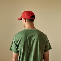 A man wear green t-shirt and red cap face clothing apparel.